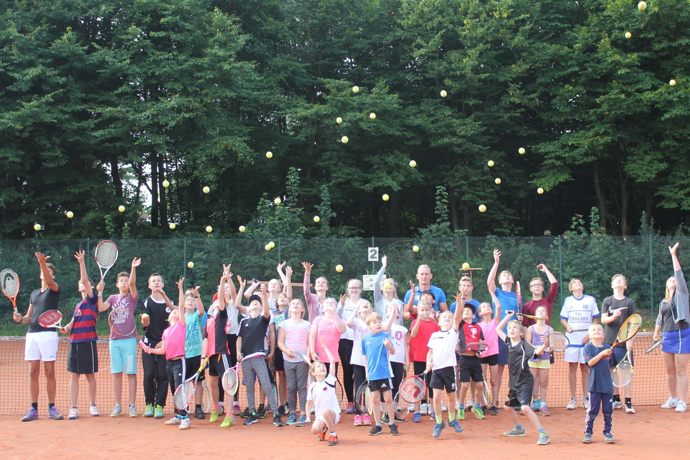Kinder werfen Tennisbälle in dir Luft